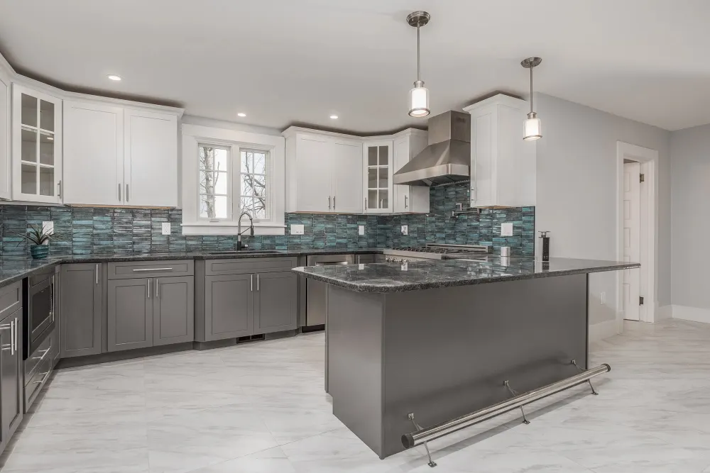 Finished kitchen with granite island and glass tile backsplash